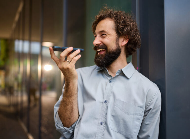 homme au téléphone le tenant dans sa main