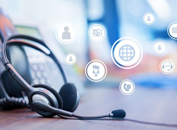 close up focus on call center headset device at VOIP system on telephone machine with virtual interface of communication at office desk for hotline telemarketing and network operation concept