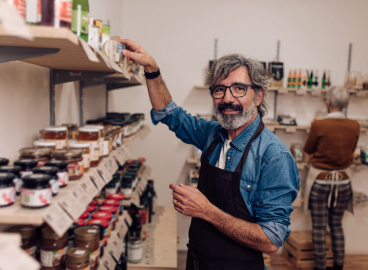 Homme triant les conserves de son épicerie