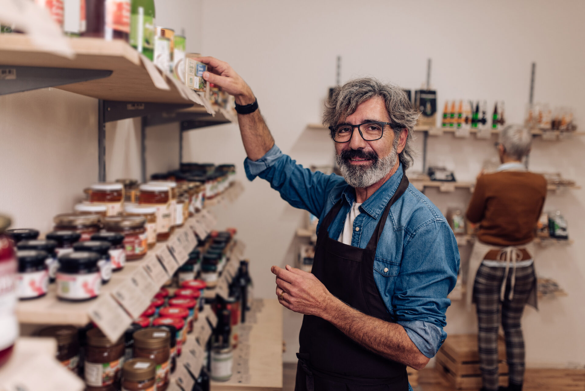 Homme triant les conserves de son épicerie