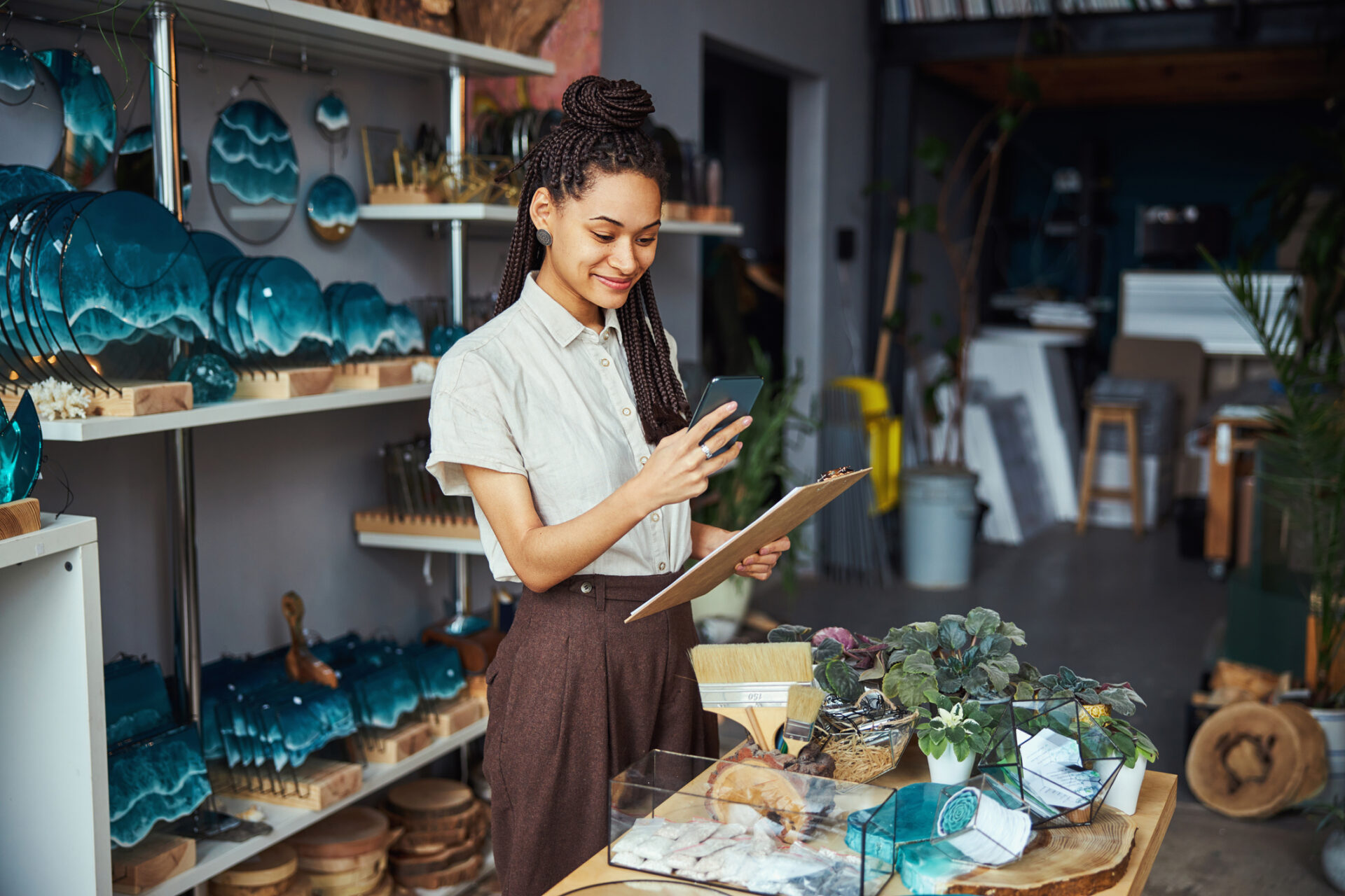Gérante d'une boutique de décoration sur son téléphone