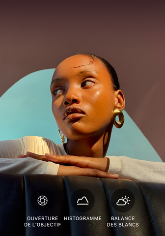 Portrait lumineux en gros plan d’une personne sur un fond coloré, illustrant l’interface des commandes Pro du système caméra pro : ouverture, histogramme, balance des blancs
